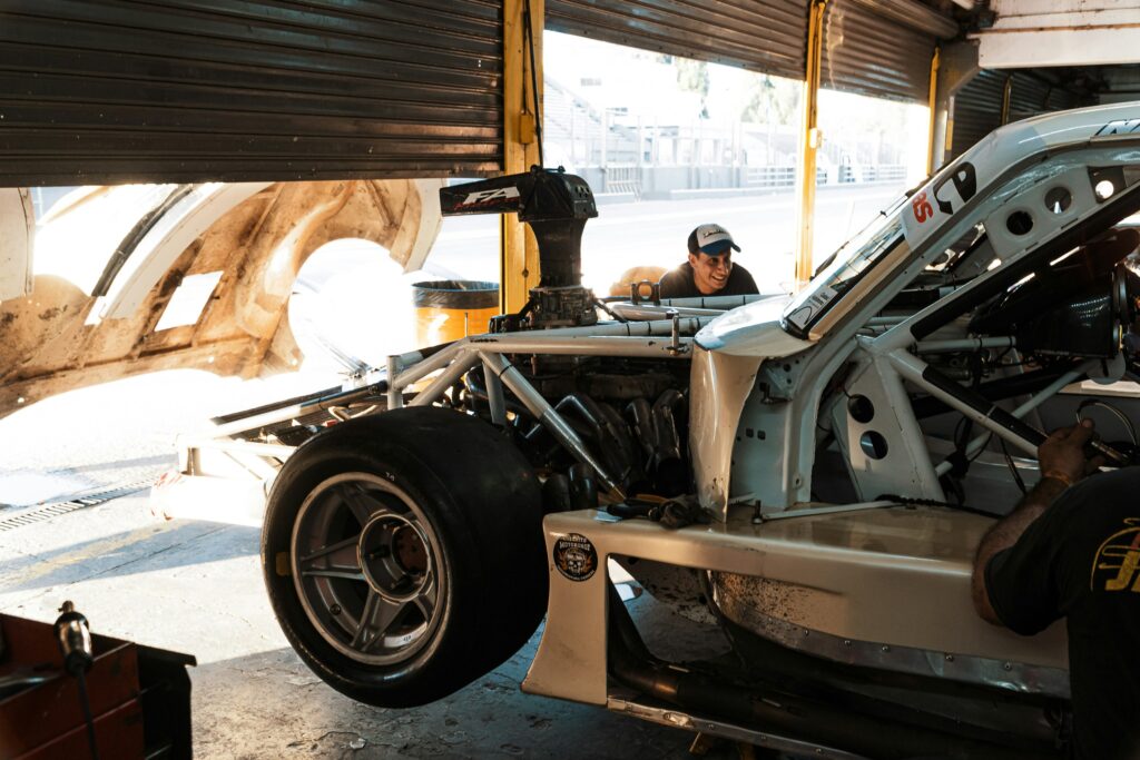 A man working on an off-road truck at an auto body shop.