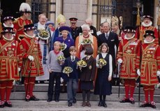 photo of Queen Elizabeth of England, her husband, church dignetaries, a royal guard, and a group of well dressed school children holding flower bouquets