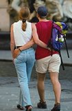 photo of a North American young adult couple walking together, each with an arm around the other person