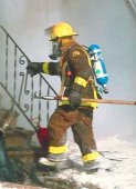 photo of a fireman going into a burning, smoke filled building