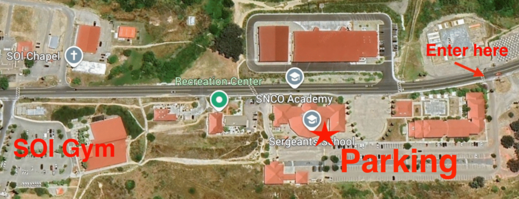 Aerial map of a section of Camp Pendleton with labeled landmarks and directions. “SOI Gym” is marked on the left side of the map. To the right, a large parking lot near the Sergeants School is labeled “Parking” with a red star. An arrow labeled “Enter here” points to an entrance along the main road on the far right. Nearby locations include the SOI Chapel, Recreation Center, and SNCO Academy, with roads and pathways connecting the area.