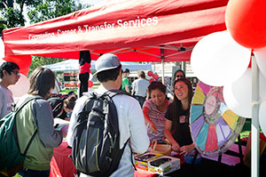 Students standing at the Counseling Career and Transfer Center Services Information tent