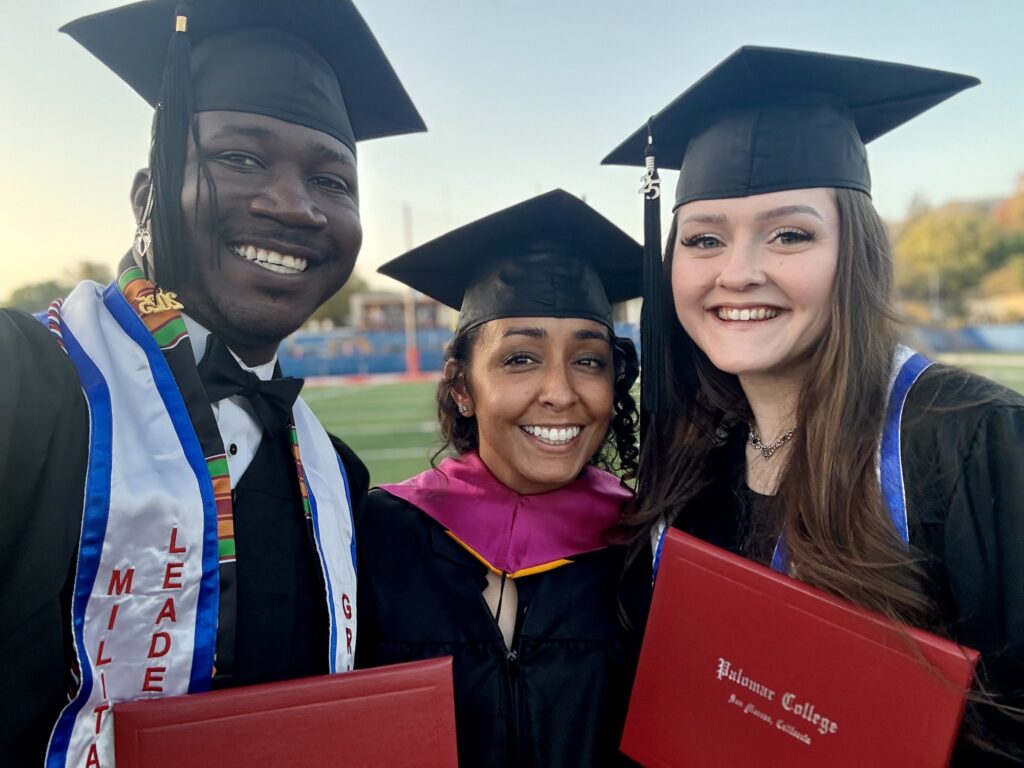 Two students and faculty at graduation.