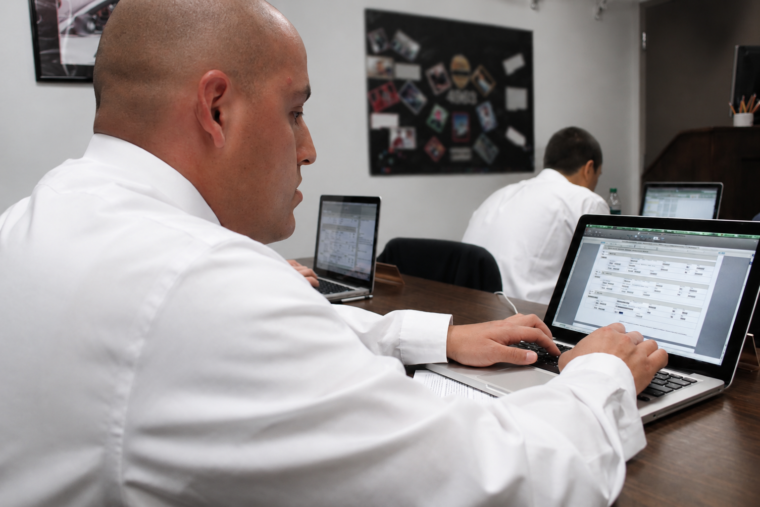 Man sits at a computer in a classroom.
