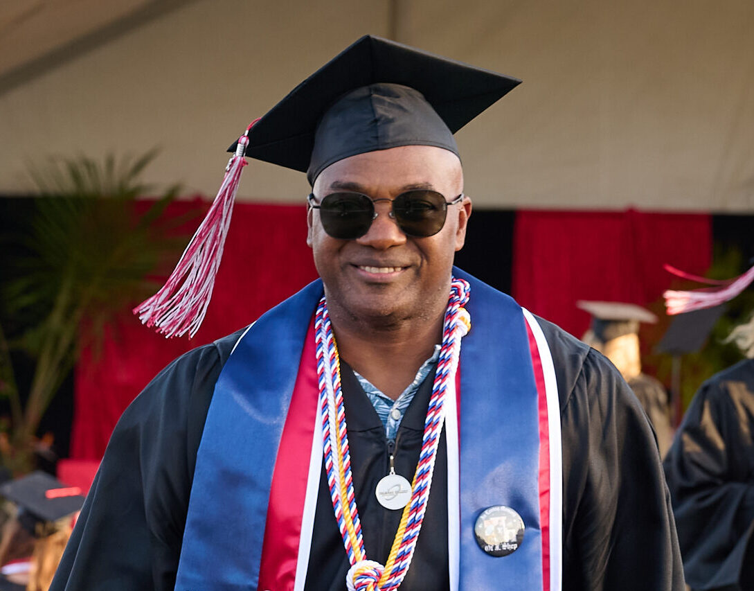 Veteran student in cap and gown at the Palomar College graduation ceremony.