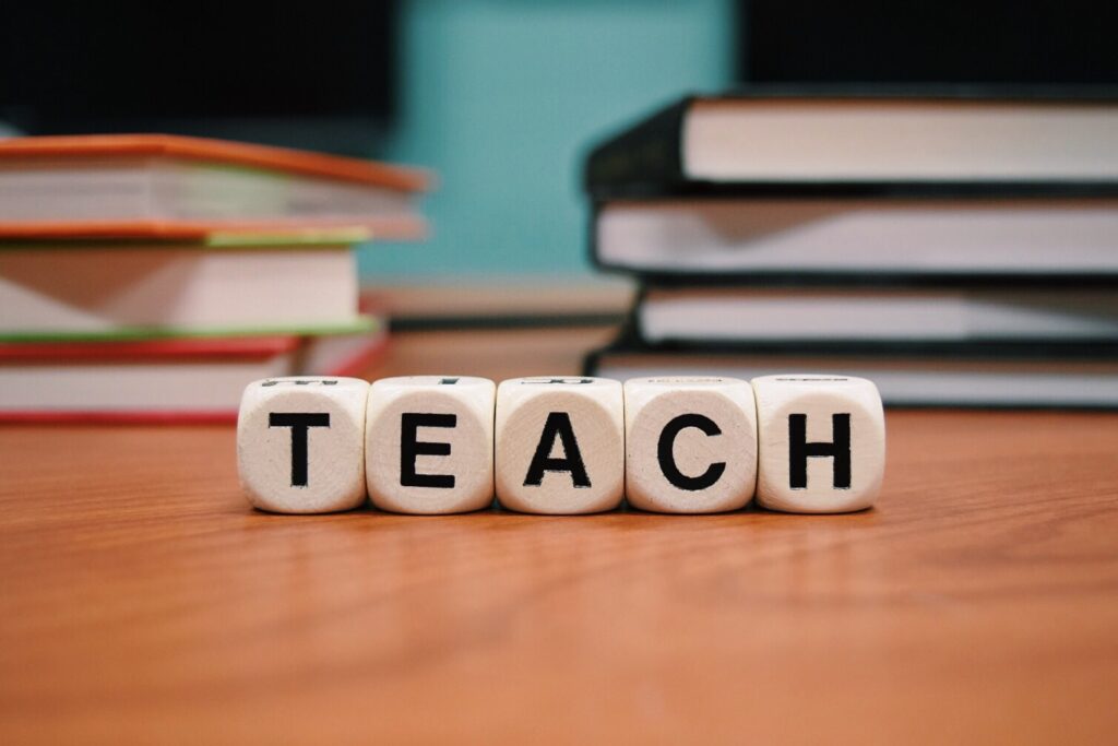 Letter blocks on a desk that spell Teach
