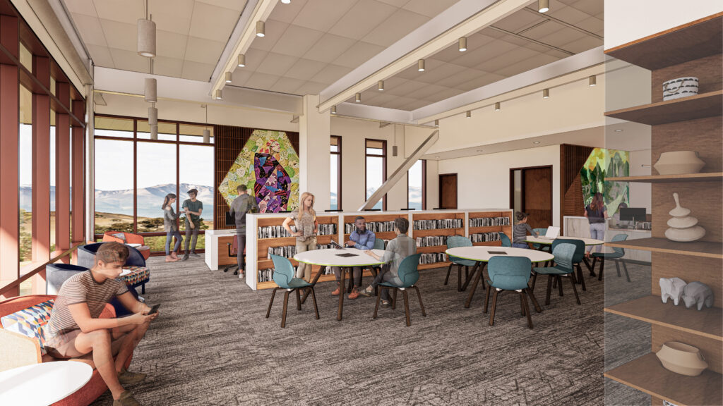 Wide view of the Fallbrook Education Center library with study seating, shelving, artwork, and natural daylight.