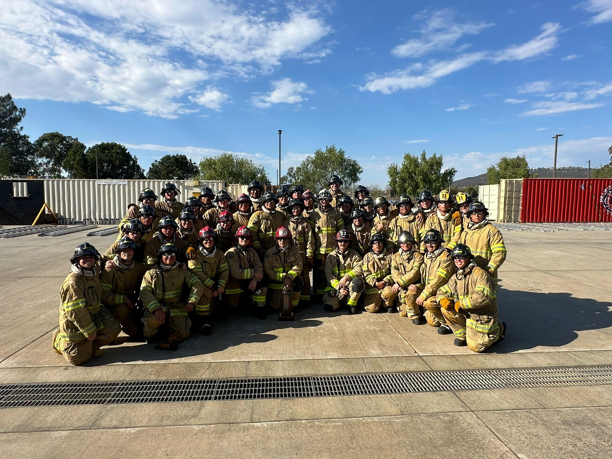A photo of a big group of firefighters wearing their uniforms.