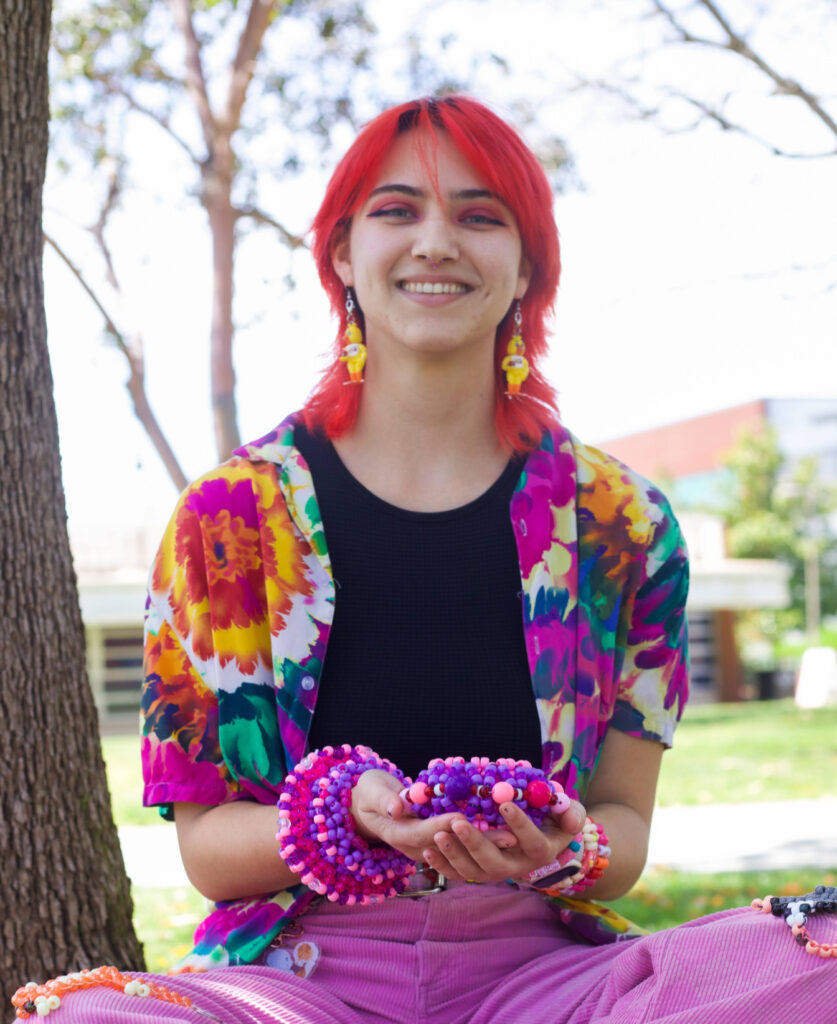 Palomar student Chloe Saye shows her collection of beads on campus.