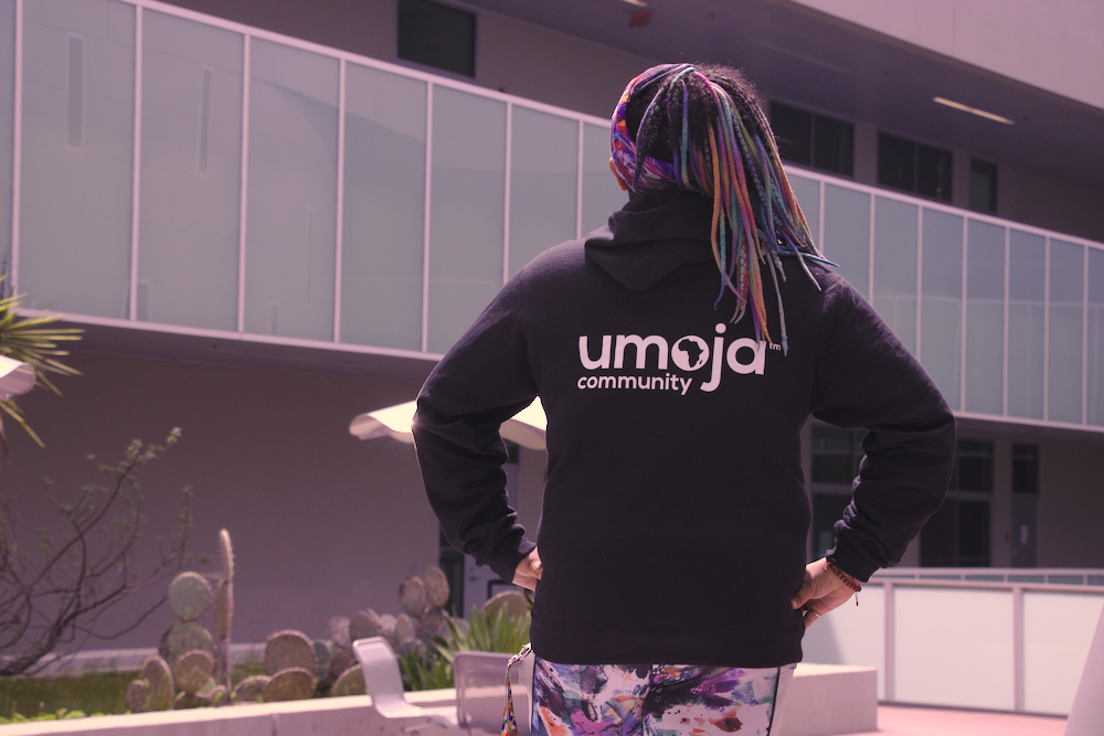 Umoja Club council representative Chanti Turner shows off the back of her hoodie with the words "Umoja community."