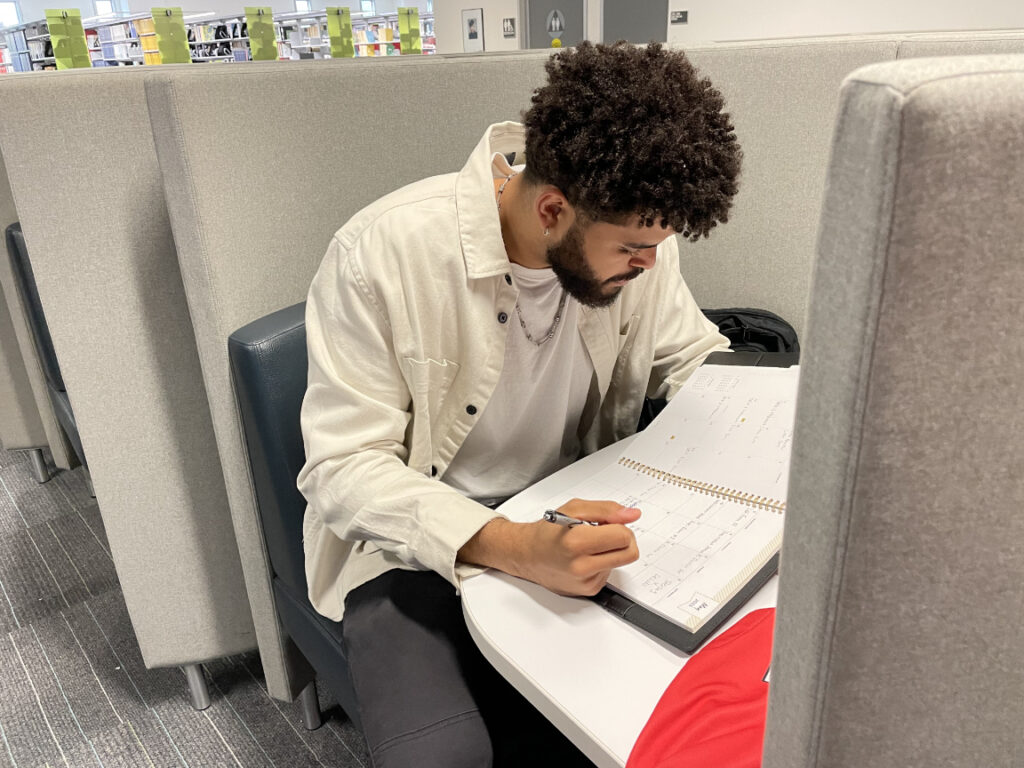 Palomar student Kryztian Walton looks at his planner at the Palomar College library.