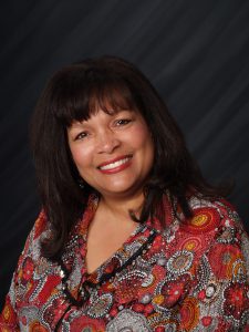 A portrait of a smiling lady with dark hair.