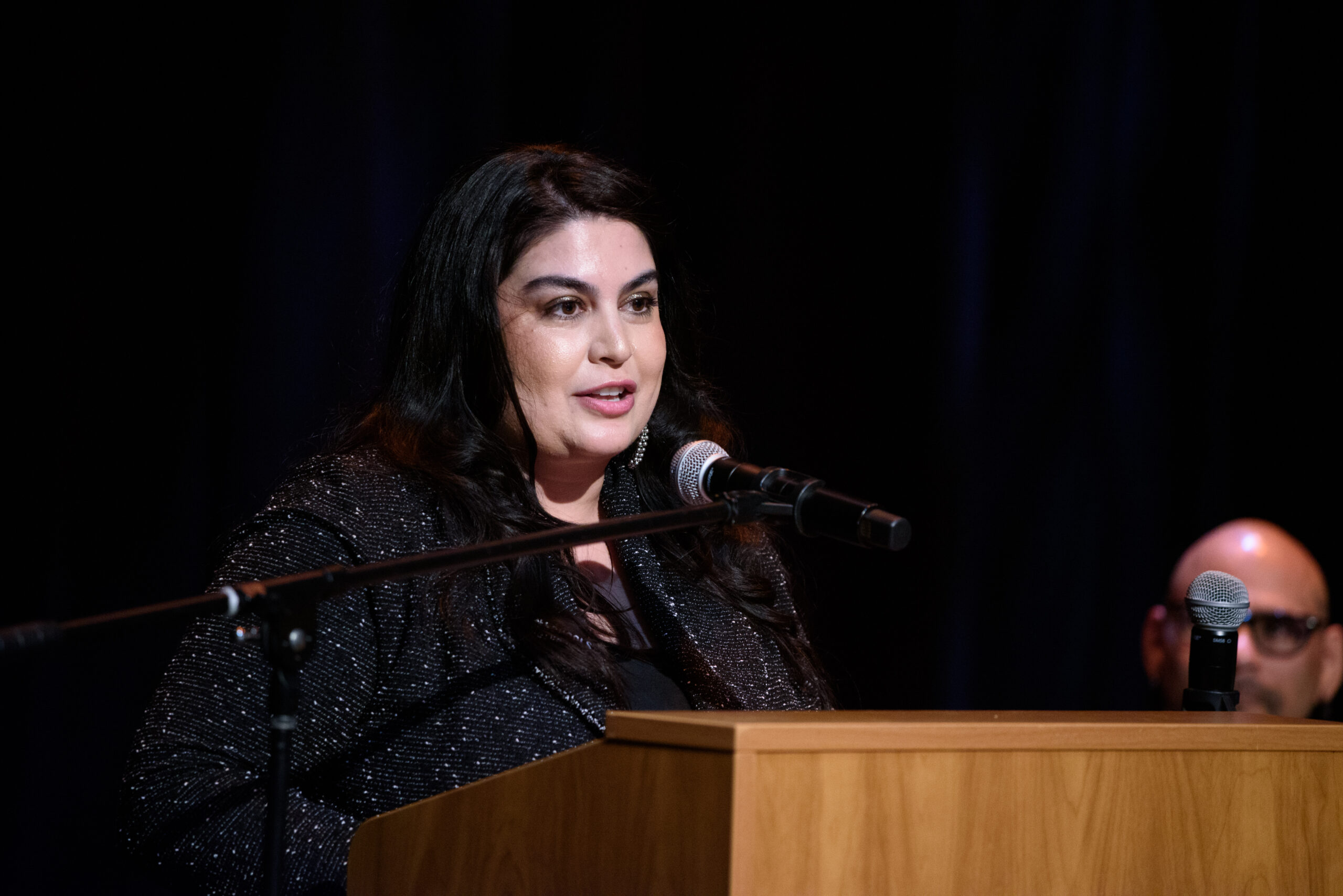 Speaker standing at podium speaking into a microphone