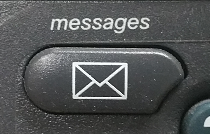 An image of the voicemail button on a older model of Cisco phone.