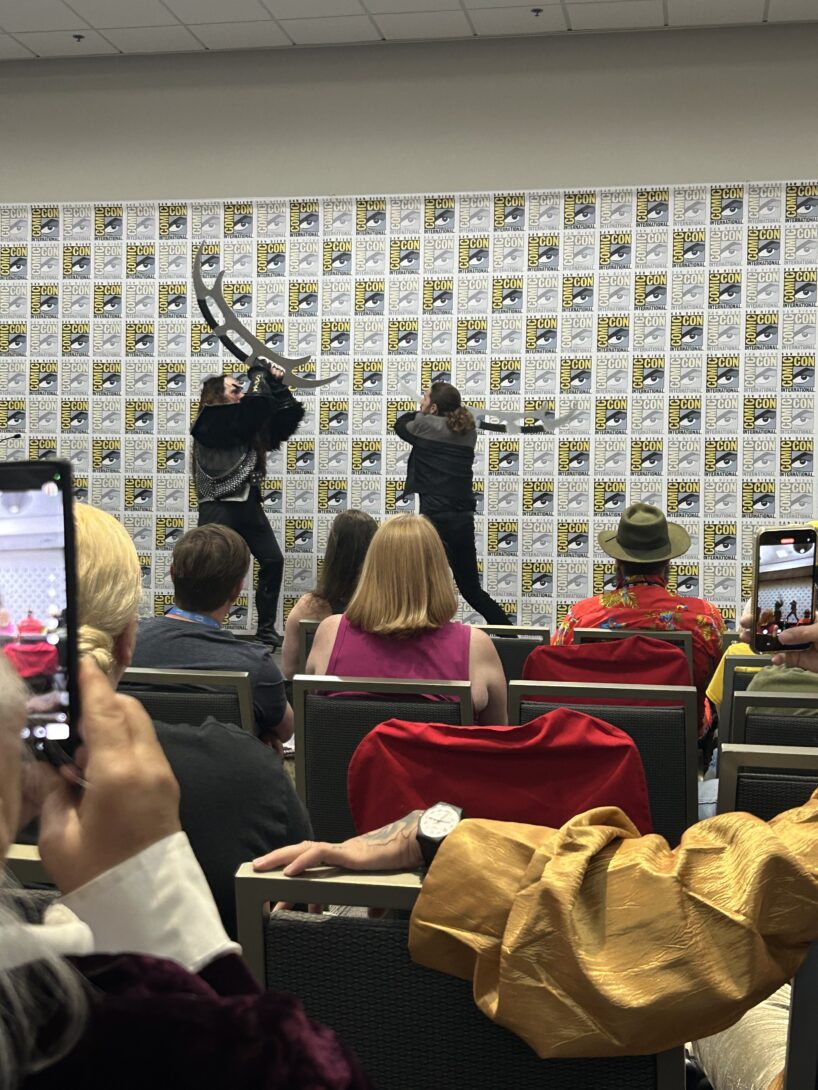 One man dressed as a Klingon and another man dressed as a Star Trek captain fight with fake blades on stage