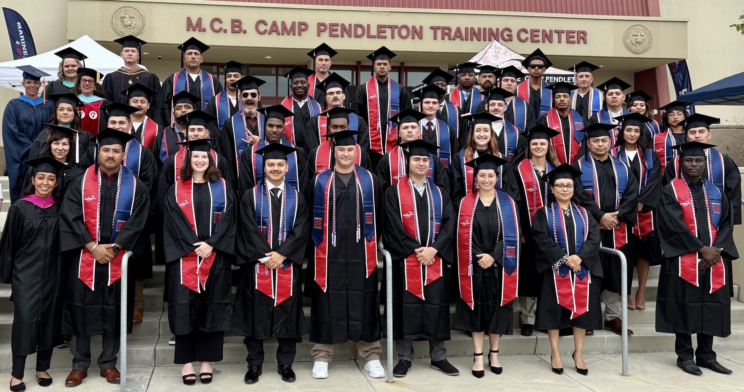 Students in graduation regalia in front of the M.C.B. Camp Pendleton Training Center