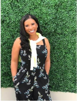 Photo of Dr. Rhonda Kirkby standing in front of greenery.