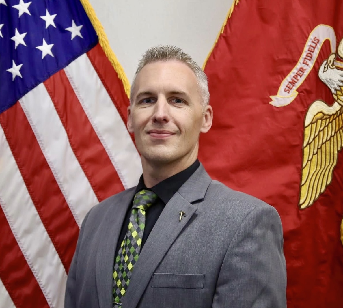 Headshot of Seth Rhyne against the Amerian and Marine Corps flags.