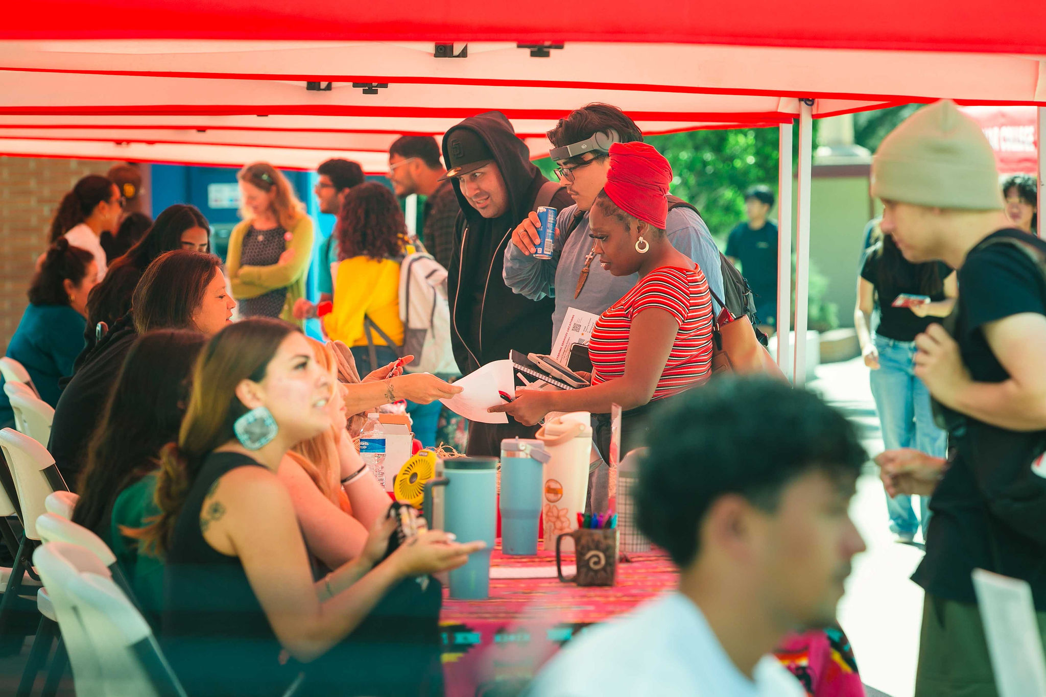 Resource Fair Connects Students and Community Attendees seated and standing under red canopies engaging with resource tables during California Native American Day.