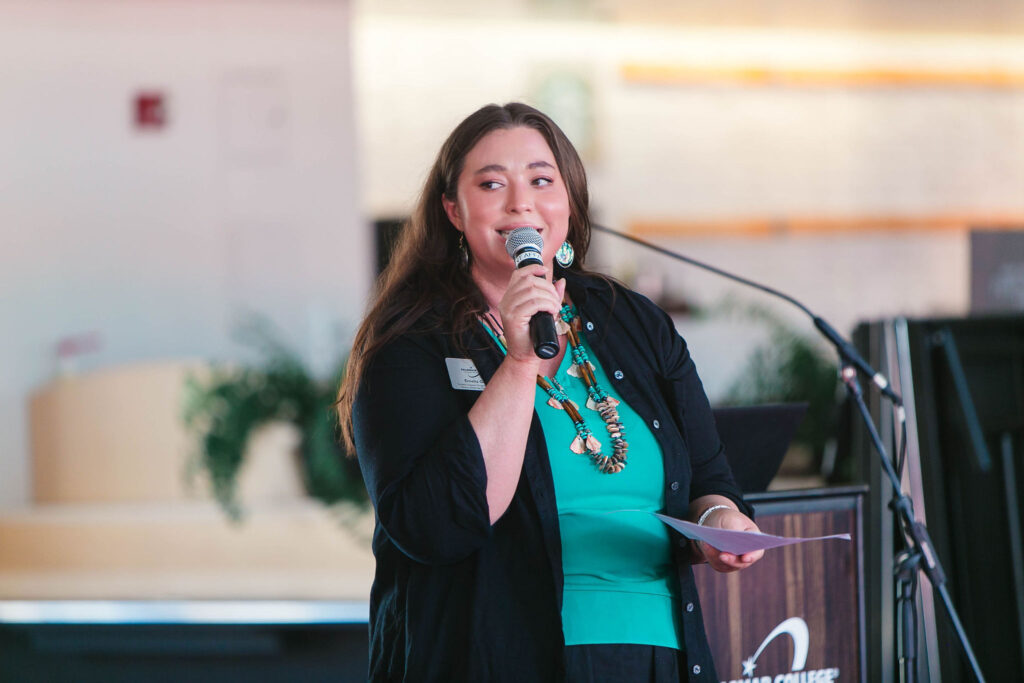 Individual speaking at podium with a microphone indoors during California Native American Day.