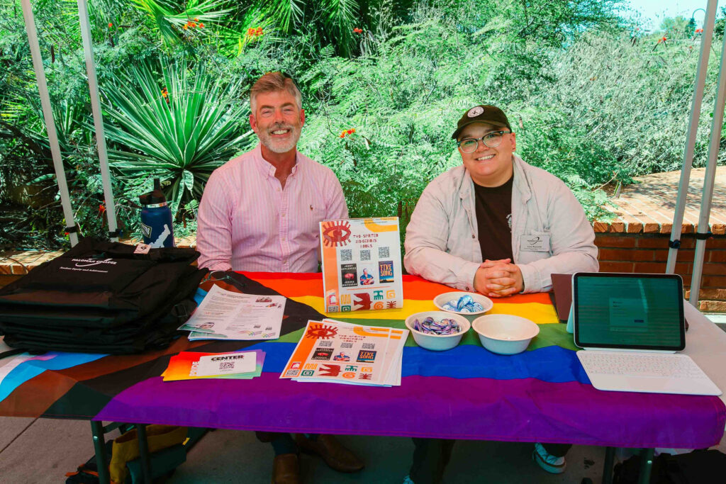 Table with informational materials under a red canopy during California Native American Day.