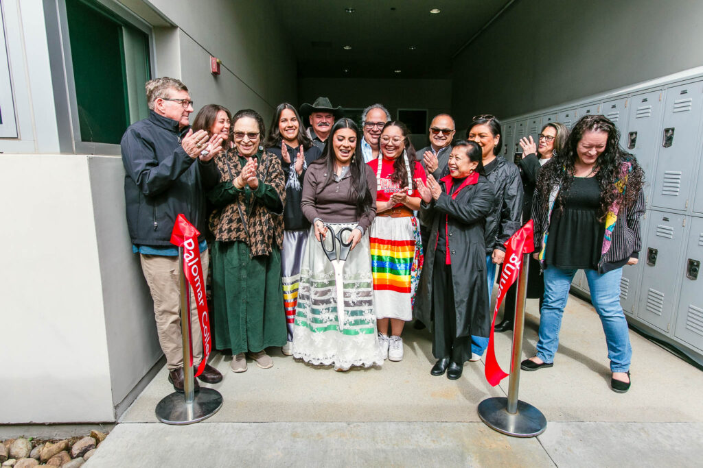 People smile and clap as the ribbon is cut to open the Native Center.