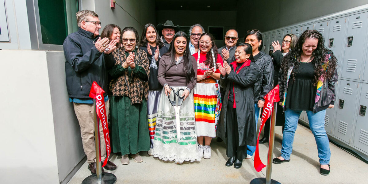 People smile and clap as the ribbon is cut to open the Native Center.