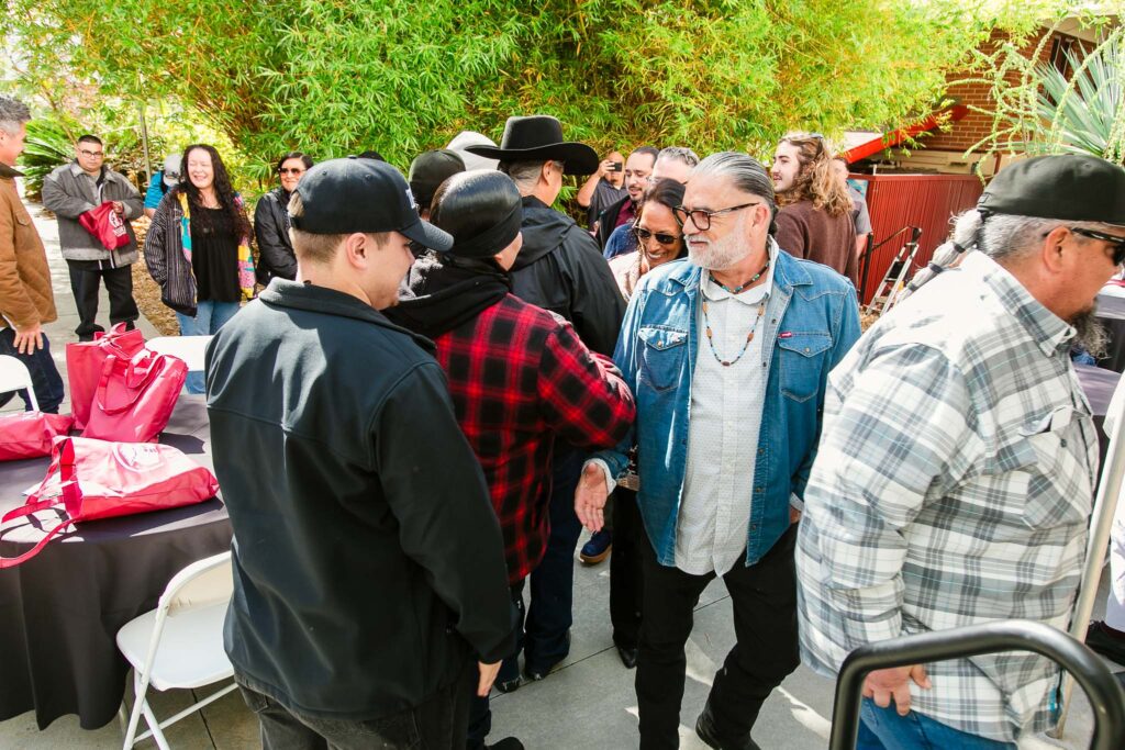 People form a line to shake hands with group of performers.