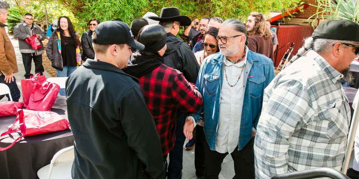 People form a line to shake hands with group of performers.