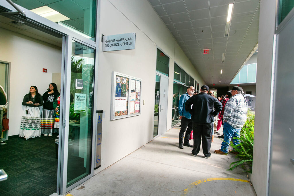A gathering of attendees standing outside of the Resource Center surrounded by greenery.