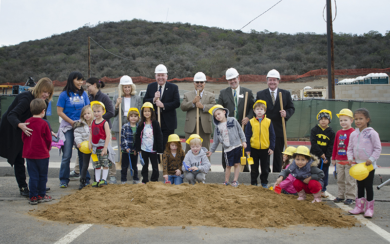 Palomar leadership with a group of kids wearing hardhats at the ECELS groundbreaking