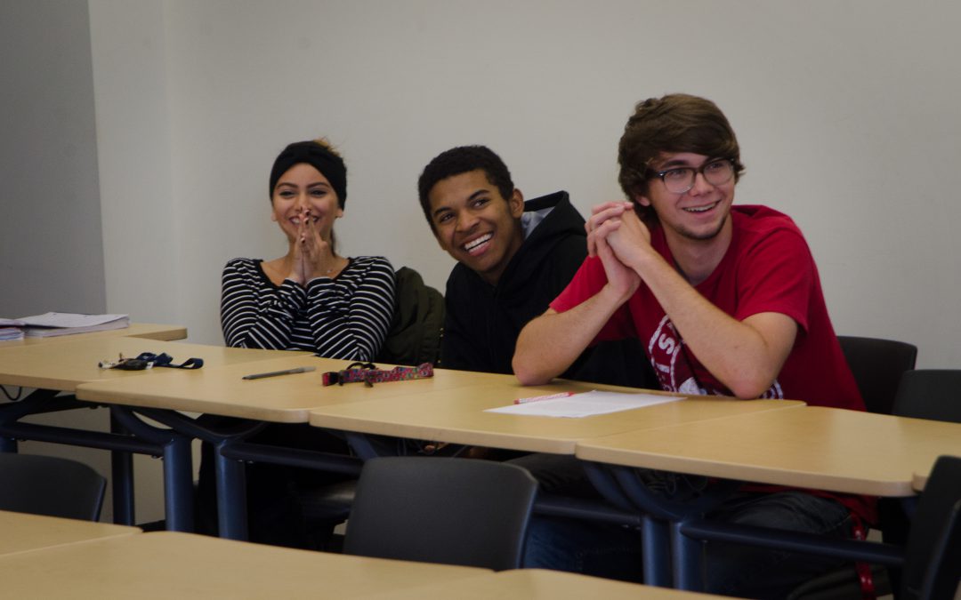 Three ASL students in class laughing together