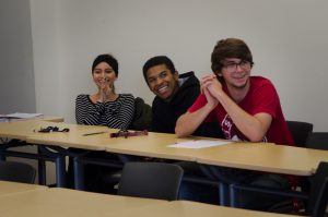 Three ASL students in class laughing together