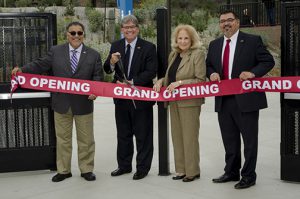 Palomar leadership standing behind a red grand opening ribbon at the baseball field