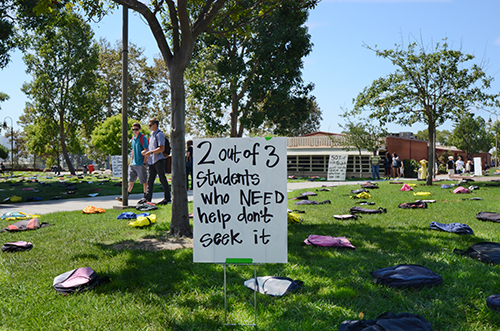 Sign in campus lawn that reads '2 out of 3 students who need help don't seek it'