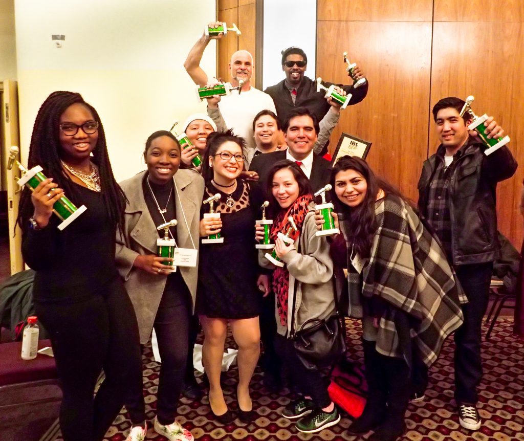 Group of staff members from the Palomar College Radio Station KKSM holding trophies and celebrating