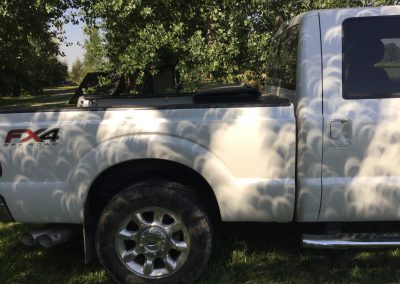 The eclipse casting crescent-shaped shadows, pictured on the side of a pickup