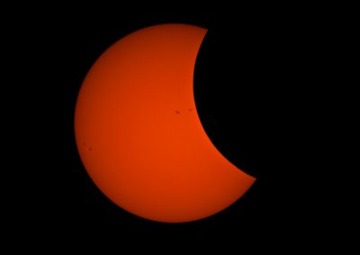 Dark sky with a red sun and view of the eclipse