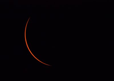 Dark sky with a red sliver of the eclipse