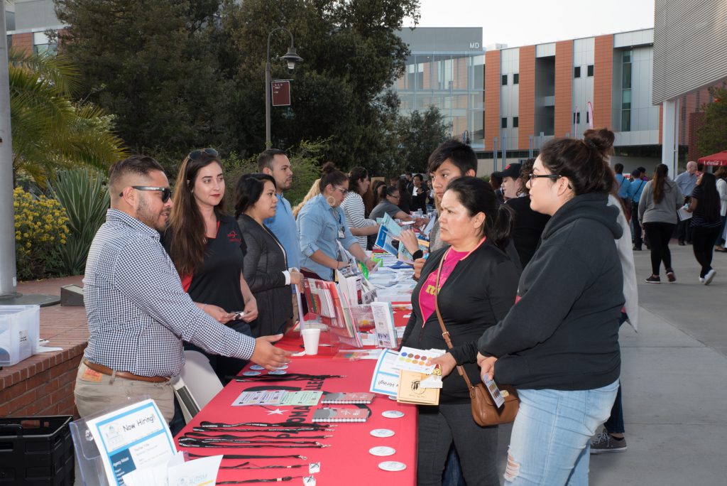 Volunteers speaking with attendees of the Tarde de Familia event