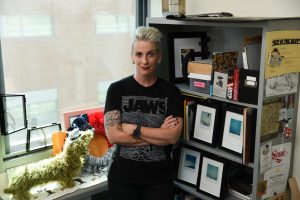 Female standing in front of a bookshelf in an office
