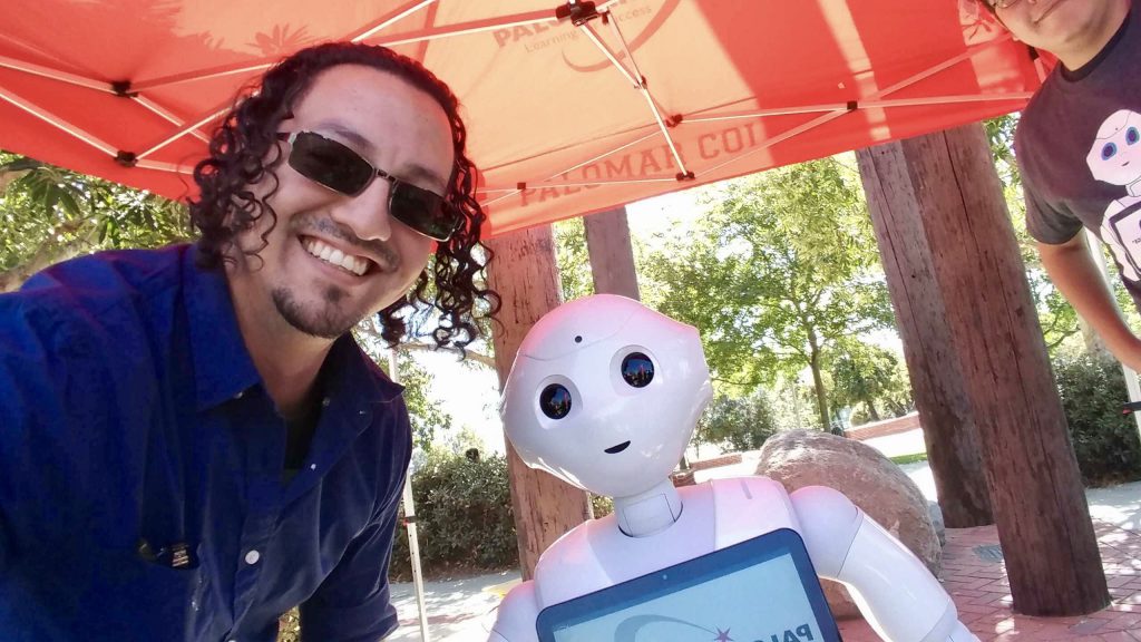 Student taking a selfie with a robot on campus