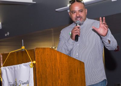 Speaker at podium holding microphone