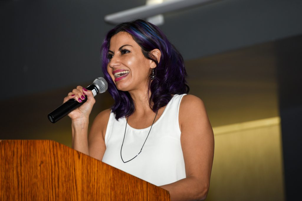 Speaker at podium holding microphone