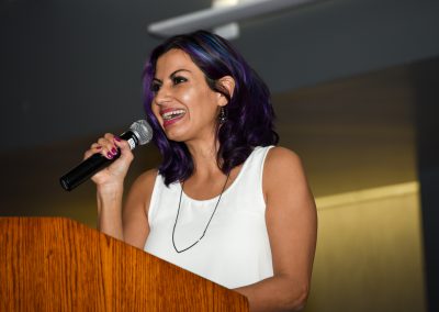 Speaker at podium holding microphone