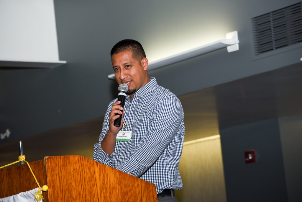 Speaker at podium holding microphone