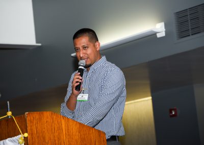 Speaker at podium holding microphone