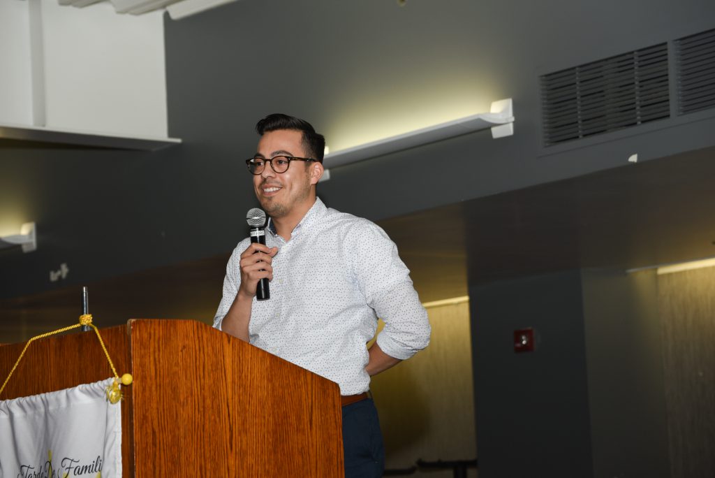 Speaker at podium holding a microphone