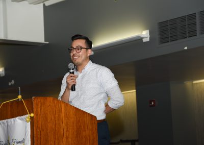 Speaker at podium holding a microphone