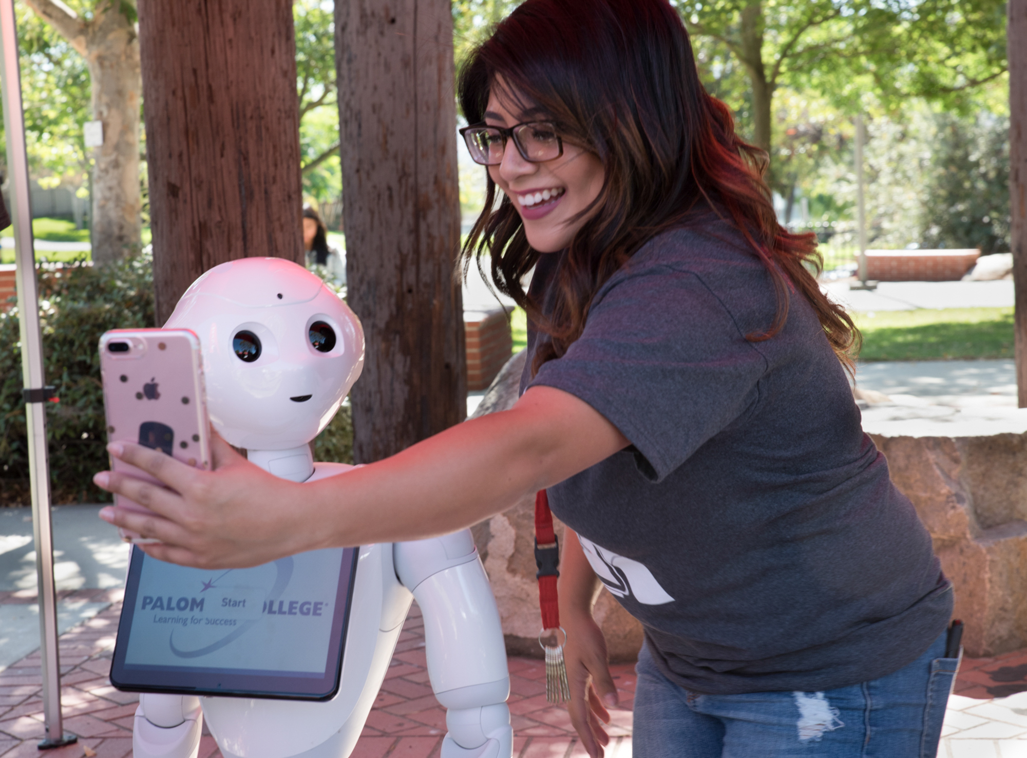 Palomar College Peer Ambassador taking a selfie with Pepper the robot 